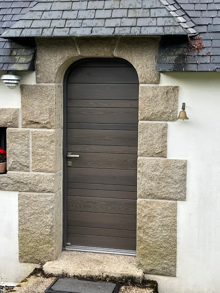 Arched exterior door installed in a stone facade